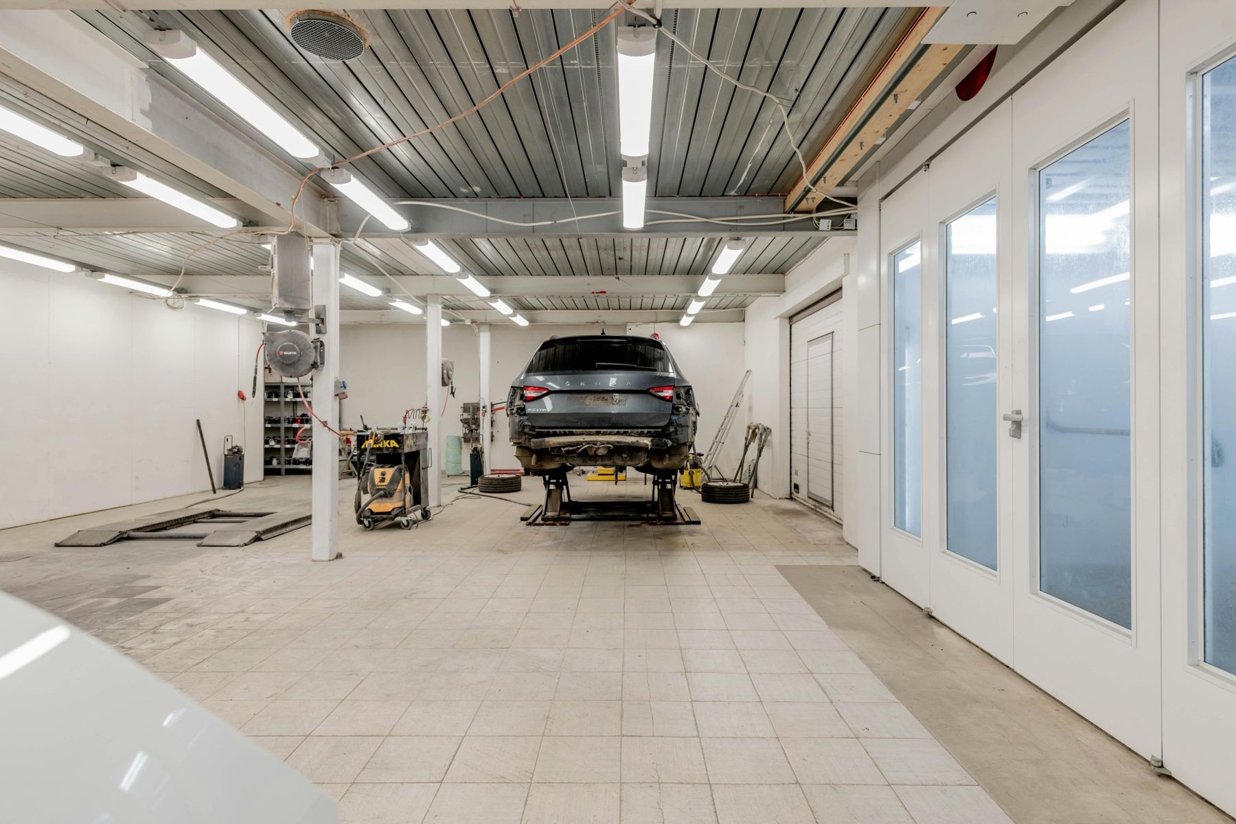 Innenansicht einer modernen Werkstatt mit Fahrzeug auf Hebebühne